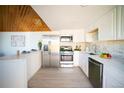 Bright kitchen with stainless steel appliances, white cabinets, and wooden ceiling at 665 S Meade St, Denver, CO 80219