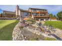 Expansive backyard featuring a multi-level deck, stone water feature, and lush landscaping at 3191 W 151St Ct, Broomfield, CO 80023