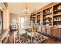 Elegant dining room featuring a large wooden table, custom built-ins, and a chandelier at 3191 W 151St Ct, Broomfield, CO 80023