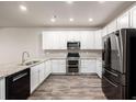 Modern kitchen featuring stainless steel appliances, white cabinets, and granite countertops at 185 Ambrose St, Erie, CO 80516