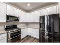 Modern kitchen featuring stainless steel appliances, white cabinets, and granite countertops at 185 Ambrose St, Erie, CO 80516