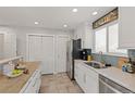 Well-lit kitchen boasts white cabinets, stainless steel appliances, and a tile backsplash at 16320 E Radcliff Pl # A, Aurora, CO 80015