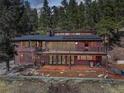Two-story house featuring a deck and patio spaces, perfect for outdoor living and entertaining at 205 Yankee Creek Trl, Evergreen, CO 80439