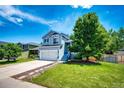 Beautiful two-story home with blue siding, front lawn, and concrete driveway at 8930 Apache Plume Dr, Parker, CO 80134