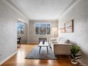 Inviting living room featuring hardwood floors, large window, and comfortable seating at 1130 N N Pennsylvania St # 306, Denver, CO 80203