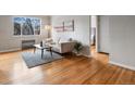 Living room with hardwood floors, neutral couch, area rug, and large window at 1130 N N Pennsylvania St # 306, Denver, CO 80203