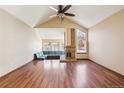 Spacious living room featuring a vaulted ceiling, fireplace, and a built-in seating area at 10262 W Ida Ave # 243, Littleton, CO 80127