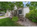 Landscaped side yard with gravel, bushes and green grass surrounding the house's siding and window at 11313 Haswell Dr, Parker, CO 80134