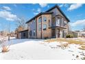 Contemporary home with snow-covered lawn and attached garage at 2800 S Dexter Way, Denver, CO 80222