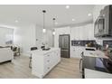 Modern kitchen featuring a central island, stainless steel appliances, and sleek white cabinetry at 1835 S Lincoln St, Denver, CO 80210