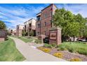 Brick apartment building with manicured landscaping and clear community signage, setting a welcoming tone at 301 Inverness S Way # 202, Englewood, CO 80112