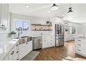 This bright kitchen features stainless appliances, floating shelves, and large farmhouse style sink at 767 Ellis St, Golden, CO 80401