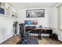 Bright home office featuring built-in shelves, modern desk setup, and wood flooring at 767 Ellis St, Golden, CO 80401