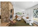 Bright and airy living room features hardwood floors, stone fireplace and large windows at 14475 Foothill Rd, Golden, CO 80401