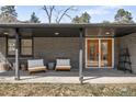 Covered porch area with contemporary outdoor seating and double door entry at 14475 Foothill Rd, Golden, CO 80401