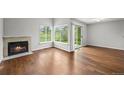 Bright living room featuring hardwood floors, a cozy fireplace, and sliding glass doors to the outside at 10349 W Fair Ave # A, Littleton, CO 80127