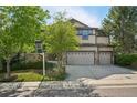 Attractive two-story home with stone accents, a two-car garage, and a green lawn in a quiet neighborhood at 13075 Tamarac St, Thornton, CO 80602
