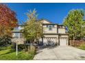 Charming two-story home featuring a stone facade, two-car garage, and well-maintained front yard with mature trees at 13075 Tamarac St, Thornton, CO 80602