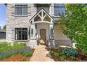 Inviting front entrance featuring a custom wood door, stone accents, and meticulously landscaped surroundings at 852 Pontiac St, Denver, CO 80220