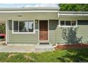 Close up of front door with a window to the left and green horizontal siding at 6155 Carr St, Arvada, CO 80004