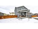 Two-story house with gray siding, covered porch, and wooden fence at 47387 Lilac Ave, Bennett, CO 80102