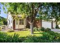 Beautiful landscaping surrounds this home, featuring mature trees and colorful flowerbeds at 1010 Home Farm Cir, Denver, CO 80234