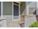 Close-up of the front door with a concrete step, white picket railing and brick facade at 1918 Depew St, Lakewood, CO 80214