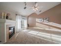 Inviting living room with a fireplace, neutral carpet, access to balcony and lots of natural light at 10381 Cook Way # 202, Thornton, CO 80229