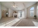 Bright living room with vaulted ceiling, fireplace, plush carpet, and sliding glass doors to a balcony at 10381 Cook Way # 202, Thornton, CO 80229