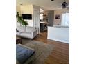Comfortable living room featuring hardwood floors, modern decor, and seamless kitchen access at 8757 W 75Th Way, Arvada, CO 80005