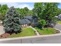 Aerial view of a two-story brick and siding home, a well-manicured lawn, mature trees, and a tree swing at 5081 S Emporia St, Greenwood Village, CO 80111