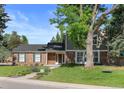 Two-story brick and siding home featuring a mature tree with a tree swing, and a lush green lawn at 5081 S Emporia St, Greenwood Village, CO 80111