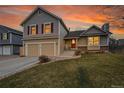 Charming two-story home featuring a two-car garage and a well-manicured front lawn under a beautiful sunset sky at 12028 W Aqueduct Dr, Littleton, CO 80127