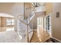 Elegant foyer with curved staircase, wood floors, and a view of the living spaces at 518 Zircon Way, Superior, CO 80027