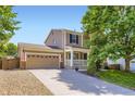 A two-story home with a front porch and a wide driveway leading to a two-car garage at 9264 Fox Fire Ln, Highlands Ranch, CO 80129