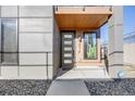 Modern townhome entrance features a stylish door with glass panels, accented by contemporary lighting and design at 3011 W 53Rd Ave, Denver, CO 80221