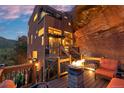 Exterior view of a unique home featuring a stone fire pit on a wooden deck and natural rock at 6619 Apache Pl, Larkspur, CO 80118