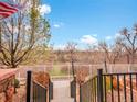 Scenic view from the porch overlooking a tranquil landscape, featuring trees and a fence-lined perimeter at 22898 E Ottawa Pl, Aurora, CO 80016