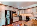 Well-lit kitchen features stainless steel appliances, wood floors, custom cabinets, and neutral countertops at 25257 Snyder Ave, Conifer, CO 80433