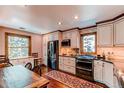 Well-lit kitchen with stainless steel appliances and an adjacent dining area at 25257 Snyder Ave, Conifer, CO 80433