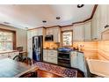 Well-lit kitchen features stainless steel appliances, wood floors, custom cabinets, and neutral countertops at 25257 Snyder Ave, Conifer, CO 80433