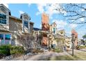 Beautiful townhouse exterior featuring a brick chimney, dormer windows, and a well-manicured yard at 2891 W Long Dr # D, Littleton, CO 80120