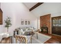 Bright living room with vaulted ceiling, brick fireplace, wood floors and modern furnishings at 2891 W Long Dr # D, Littleton, CO 80120