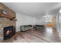 Living room with stone fireplace and hardwood floors at 3656 S Depew St # 104, Denver, CO 80235