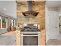 Contemporary kitchen with stainless steel range and hood set against a stylish stone accent wall at 312 Allen St, Golden, CO 80401