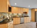 Bright kitchen with light wood cabinets, stainless steel appliances, and slate backsplash at 312 Allen St, Golden, CO 80401