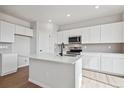 Bright kitchen features white cabinetry, stainless appliances, and island with countertop space at 3464 N Irvington St, Aurora, CO 80019