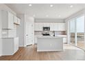 Bright kitchen features white cabinetry, stainless appliances, and island with countertop space at 3464 N Irvington St, Aurora, CO 80019