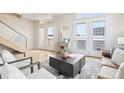 Open floor plan living room featuring hardwood floors, comfortable seating, and ample natural light at 3101 Blake St # 309, Denver, CO 80205