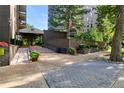 Building entrance with lush landscaping and an American flag at The Park Lane Condominiums at 460 S Marion Pkwy # 453, Denver, CO 80209